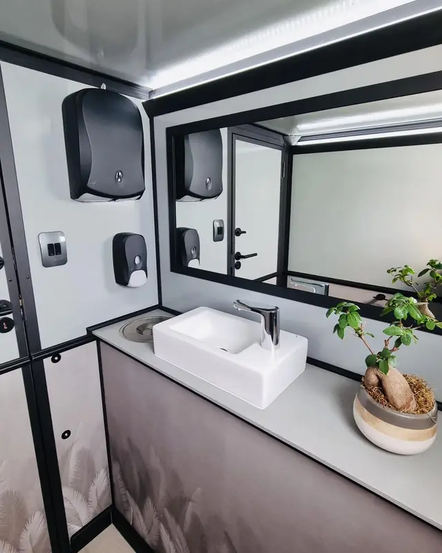 Restroom trailer vanity with a sink, faucet and mirror